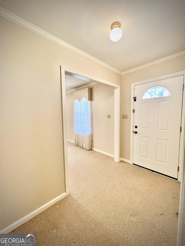 carpeted entrance foyer featuring ornamental molding and baseboards