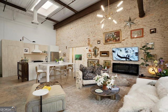 living area with beamed ceiling, a glass covered fireplace, and a towering ceiling