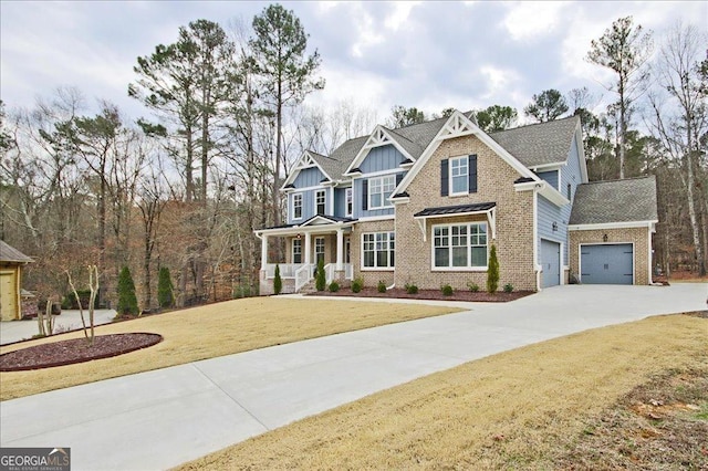 craftsman-style home with a garage, concrete driveway, covered porch, a front yard, and brick siding