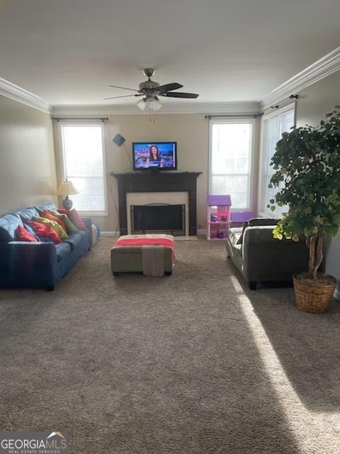 living room with carpet floors, a fireplace, crown molding, and ceiling fan