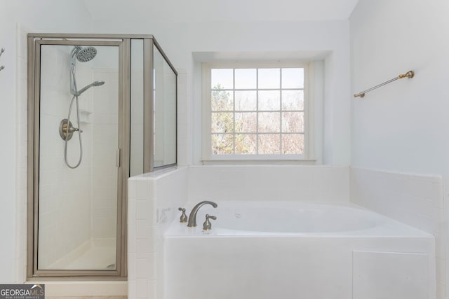 full bathroom with a shower stall and a bath