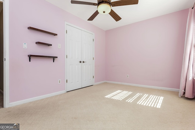 unfurnished bedroom with carpet floors, a closet, ceiling fan, and baseboards