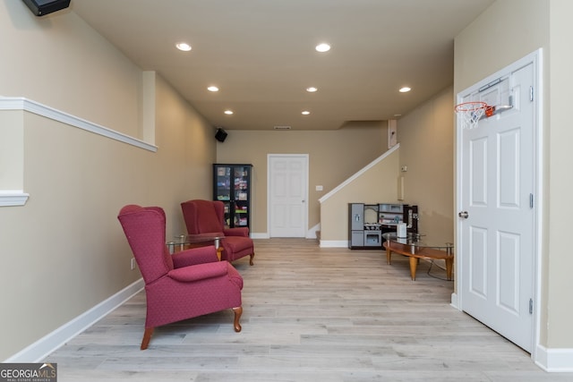 sitting room featuring light wood-type flooring, baseboards, stairway, and recessed lighting