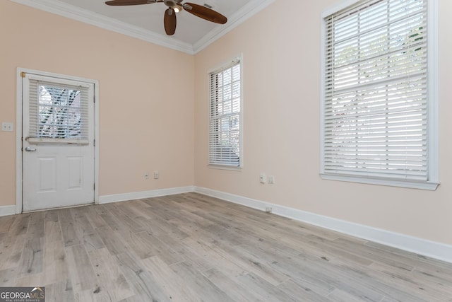 empty room featuring light wood-type flooring, ceiling fan, baseboards, and crown molding