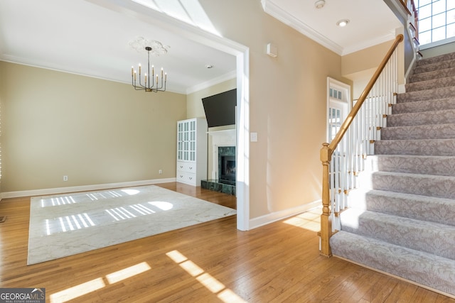 interior space with stairs, ornamental molding, hardwood / wood-style flooring, and a notable chandelier