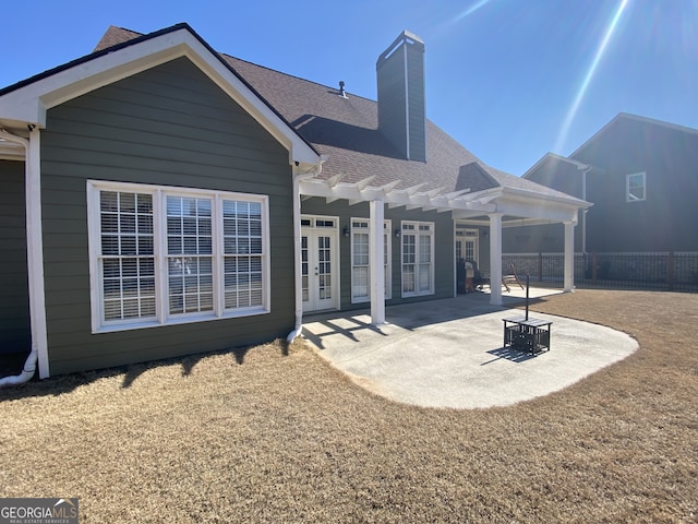 back of house featuring fence, french doors, a pergola, a chimney, and a patio area