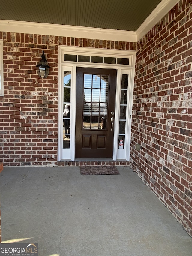 view of exterior entry featuring brick siding