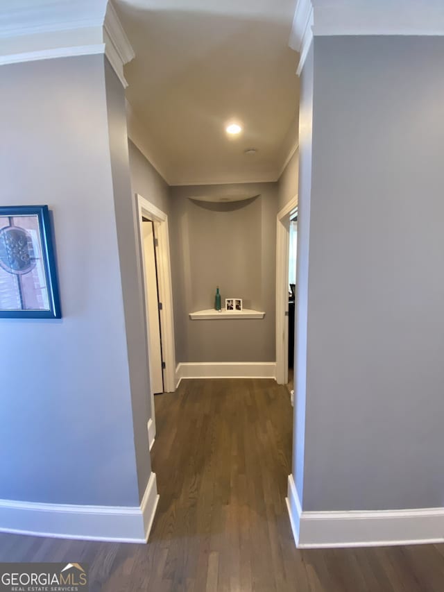 hall featuring ornamental molding, baseboards, and wood finished floors