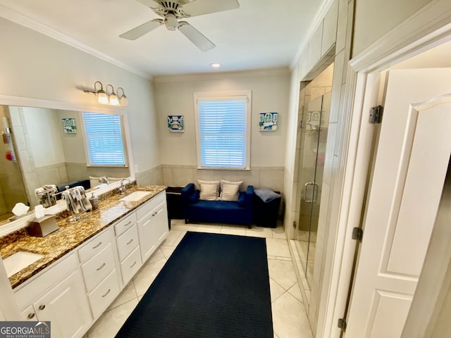 full bathroom with a stall shower, plenty of natural light, a wainscoted wall, tile patterned flooring, and a sink