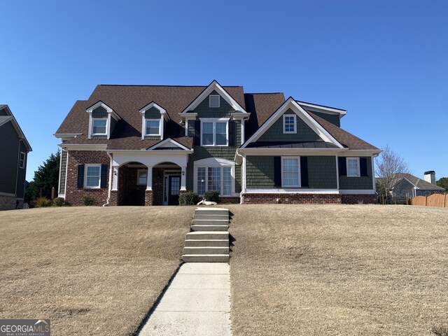 view of front of house with brick siding and a shingled roof