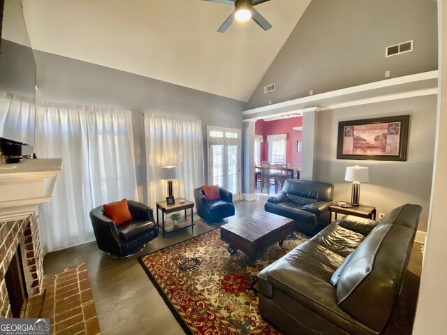 living area with high vaulted ceiling, a fireplace, visible vents, and wood finished floors