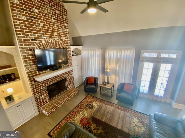 living room with built in features, french doors, a fireplace, ceiling fan, and high vaulted ceiling