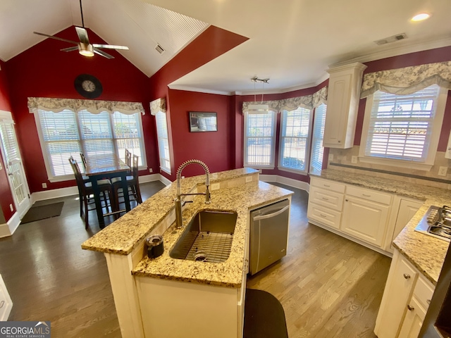 kitchen with a kitchen island with sink, wood finished floors, a sink, white cabinets, and appliances with stainless steel finishes