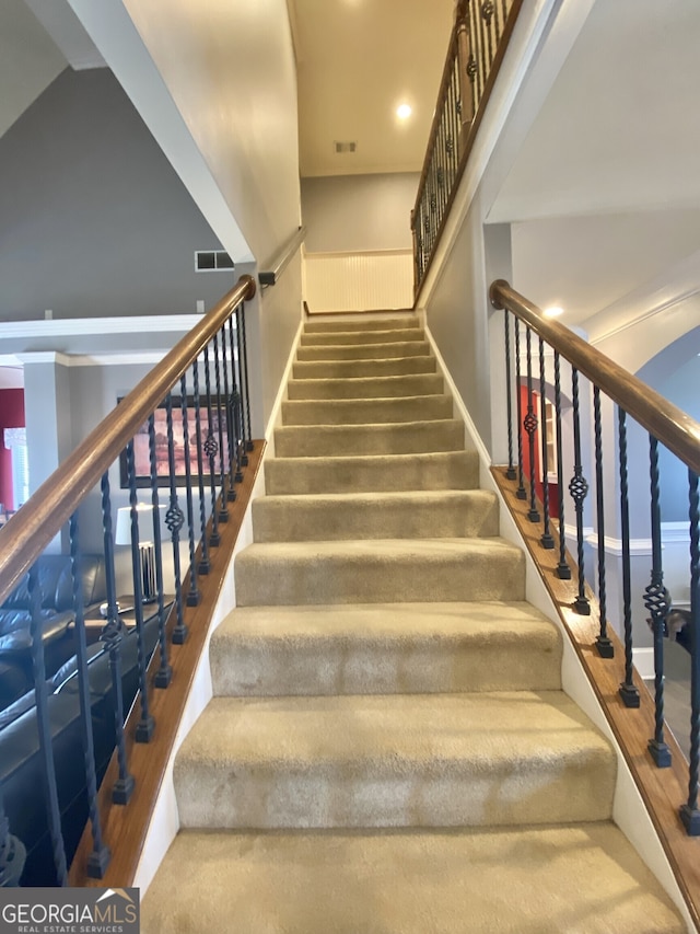 staircase featuring visible vents and wood finished floors