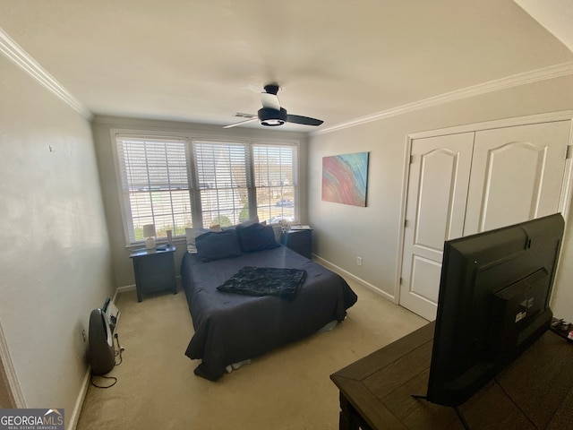 carpeted bedroom featuring baseboards, ornamental molding, and ceiling fan