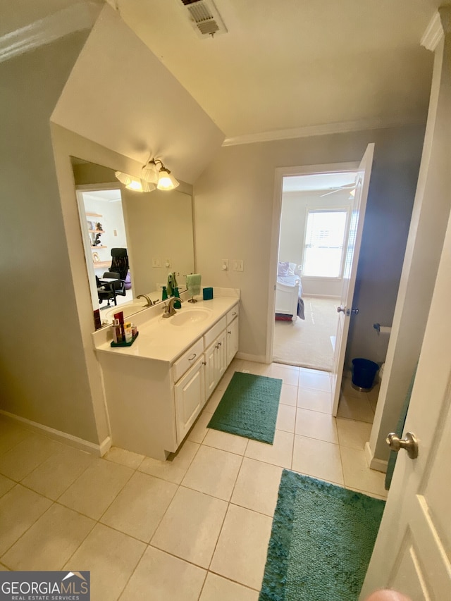 bathroom with lofted ceiling, visible vents, baseboards, vanity, and tile patterned floors