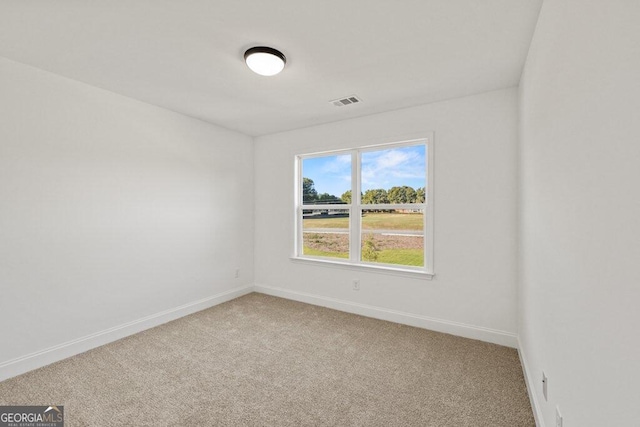 carpeted empty room featuring visible vents and baseboards