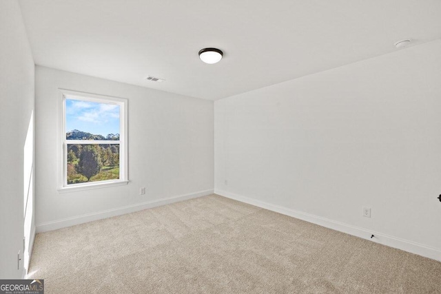 carpeted empty room with visible vents and baseboards