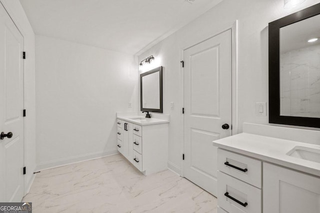 bathroom featuring marble finish floor, two vanities, a sink, and baseboards