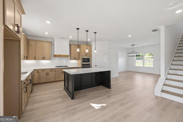 kitchen with light countertops, gas stovetop, a center island, and custom range hood