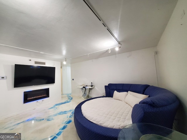 living area featuring rail lighting, a fireplace, and visible vents