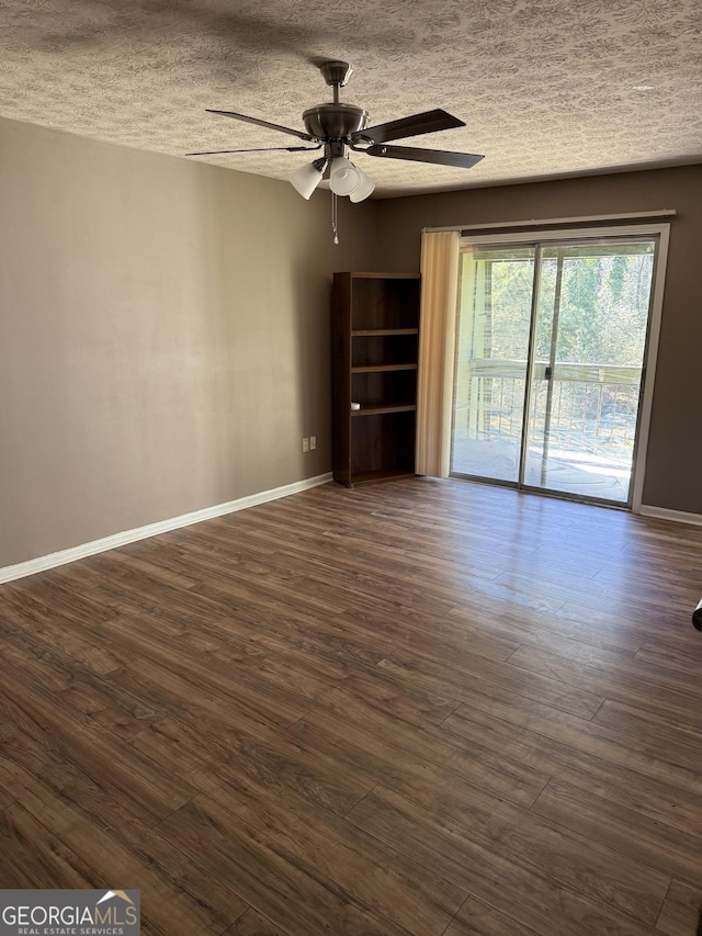 spare room with dark wood-style floors, a ceiling fan, baseboards, and a textured ceiling