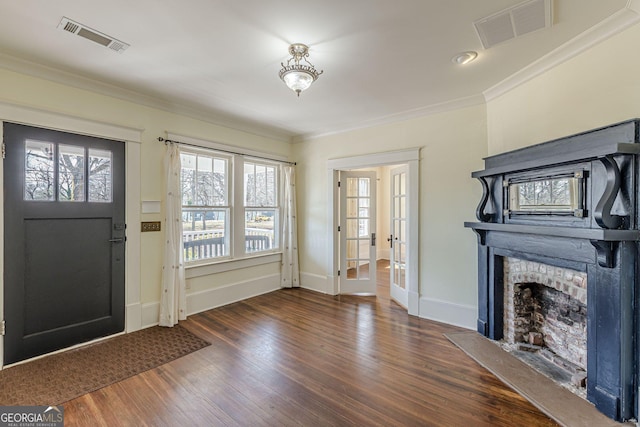 entrance foyer featuring visible vents, crown molding, baseboards, and wood finished floors