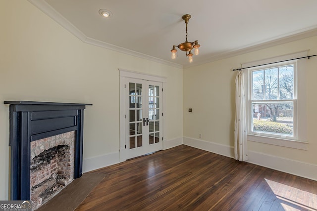 unfurnished living room with a fireplace, crown molding, a notable chandelier, baseboards, and hardwood / wood-style flooring