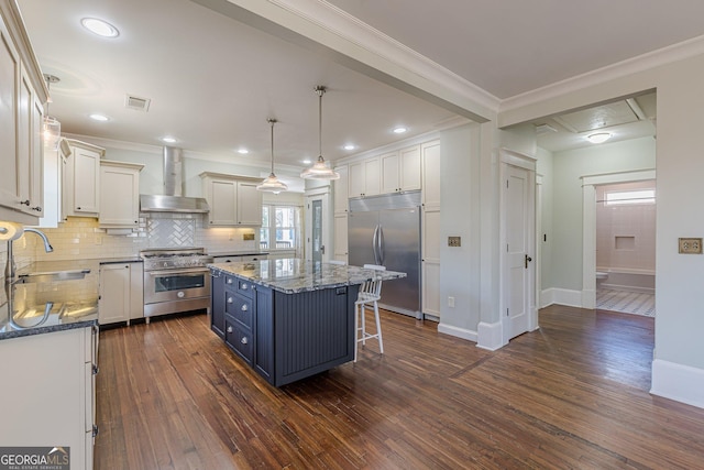 kitchen with crown molding, visible vents, a sink, high quality appliances, and wall chimney exhaust hood