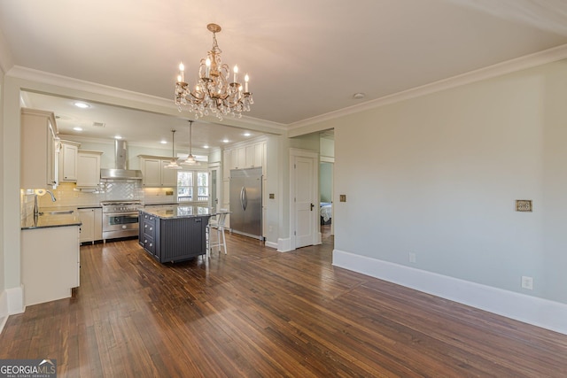 kitchen with a center island, wall chimney exhaust hood, a sink, crown molding, and high end appliances