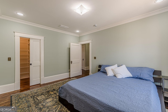 bedroom with recessed lighting, baseboards, crown molding, and wood finished floors
