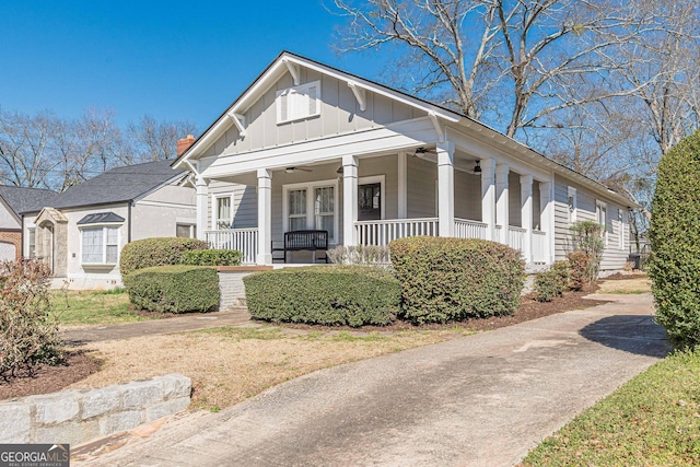 bungalow-style home with board and batten siding, a porch, ceiling fan, and a chimney