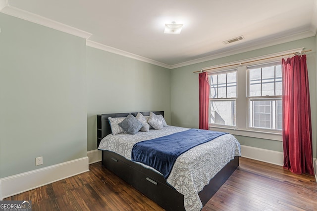 bedroom with baseboards, visible vents, hardwood / wood-style flooring, and ornamental molding