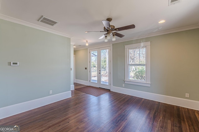 spare room with baseboards, ornamental molding, a ceiling fan, visible vents, and wood finished floors