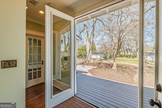 doorway to outside with recessed lighting, visible vents, crown molding, and wood finished floors