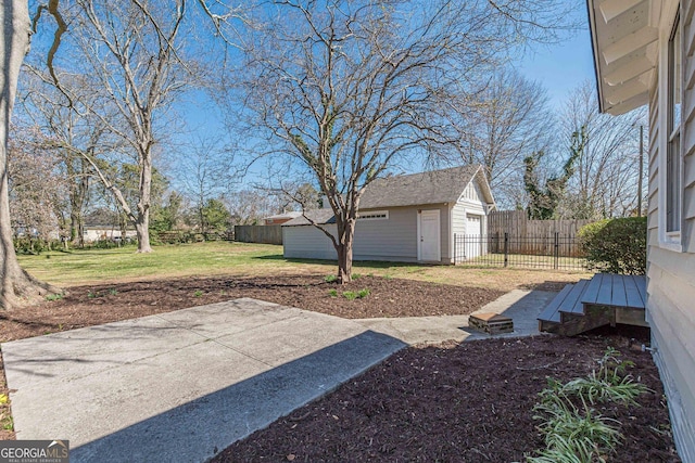 view of yard with a patio area, an outdoor structure, fence, and a detached garage