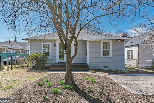 bungalow with fence, a shingled roof, and crawl space