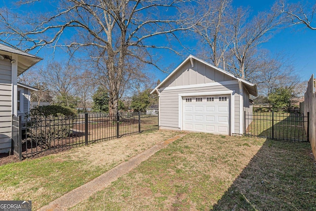 view of yard with an outbuilding, driveway, fence, and a garage