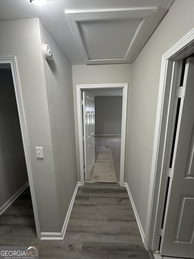 corridor with wood finished floors and baseboards