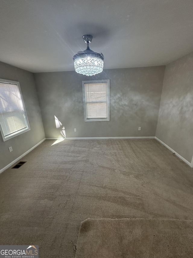 unfurnished dining area featuring carpet, visible vents, and baseboards