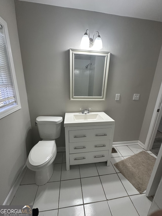 full bathroom featuring tile patterned flooring, toilet, vanity, baseboards, and walk in shower