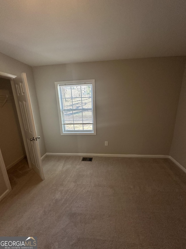 unfurnished bedroom featuring carpet floors, visible vents, and baseboards