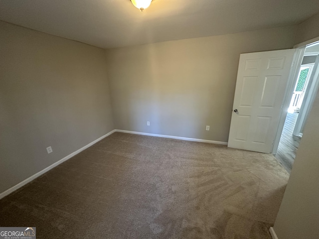 carpeted empty room with baseboards