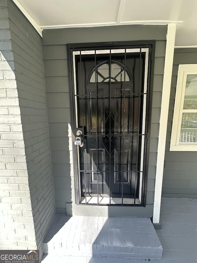 view of exterior entry featuring brick siding