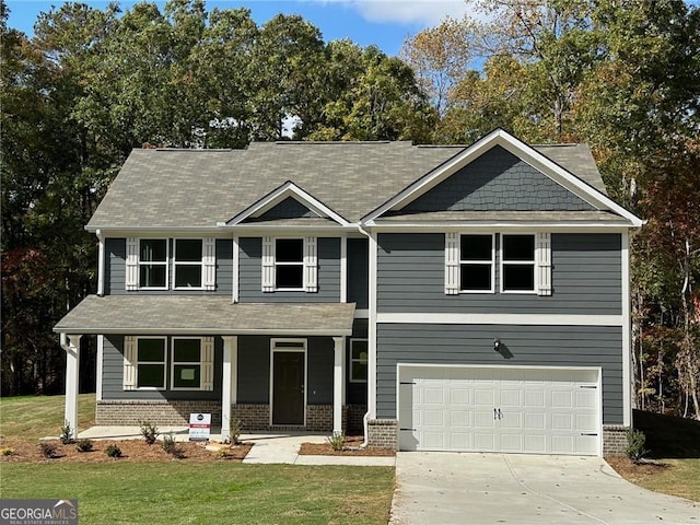 view of front of property with a porch, a front yard, brick siding, and a garage