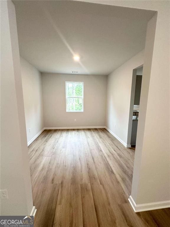 empty room with wood finished floors and baseboards