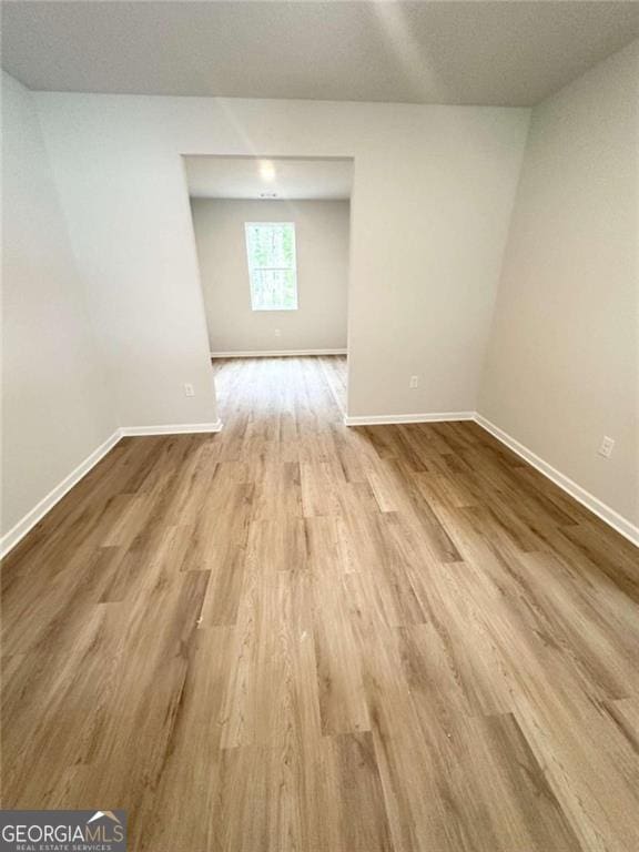 interior space featuring baseboards and wood finished floors