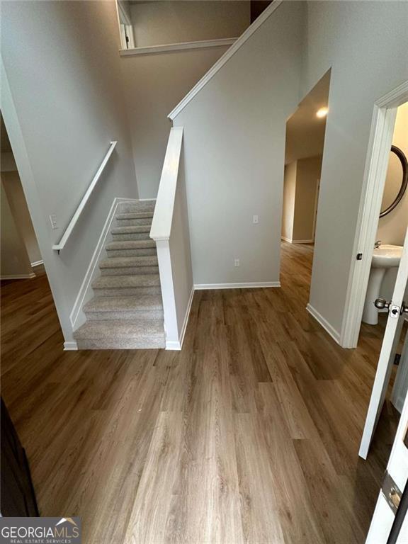 staircase featuring baseboards and wood finished floors