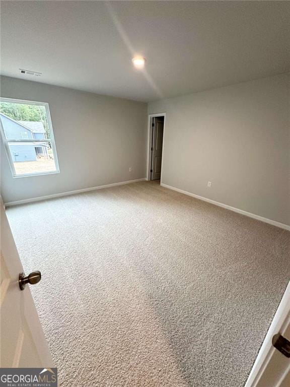 unfurnished room with carpet floors, visible vents, baseboards, and recessed lighting