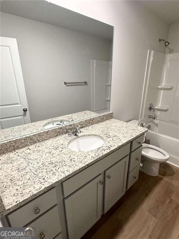 full bathroom with toilet, bathtub / shower combination, wood finished floors, and vanity